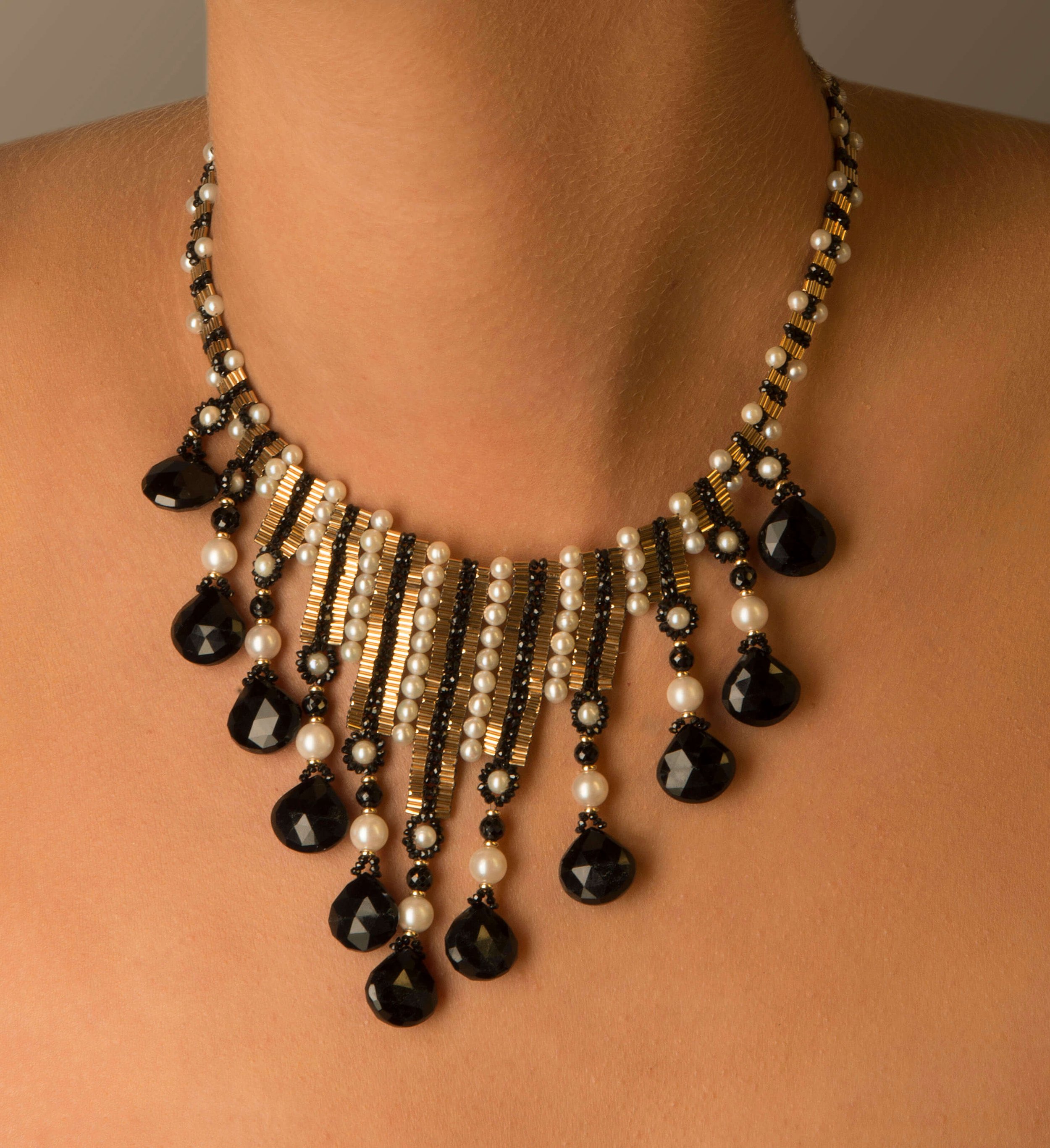 This choker is entirely hand woven of 14k gold, black spinel, white freshwater pearls, and onyx drops.
