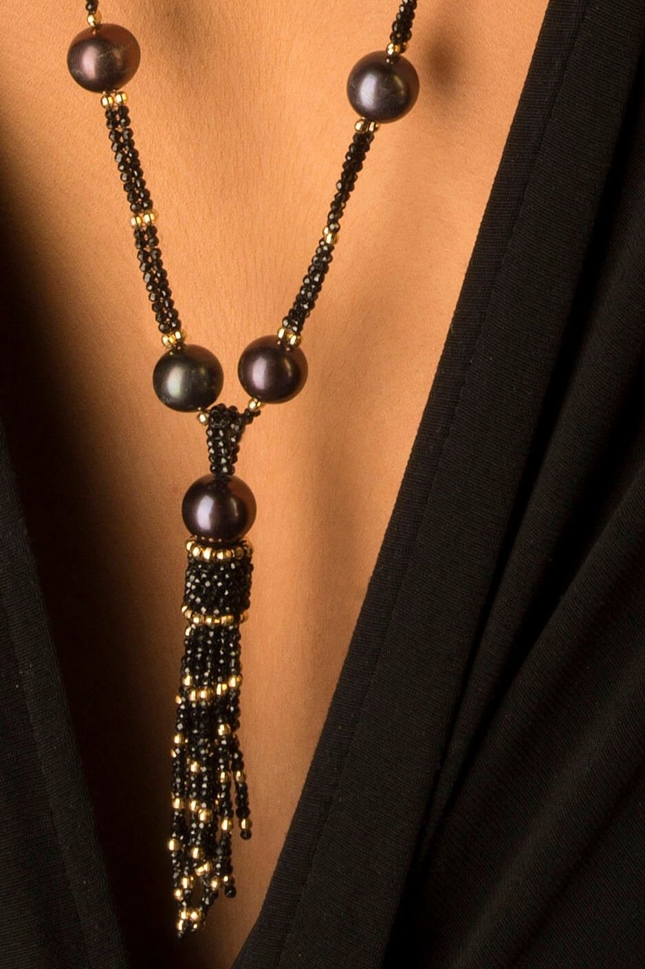 Deco Tassel.  The tassel is hand woven of black spinel,  and 14k beads,  with a Tahitian pearl positioned at the top.  The tassel hangs from a very long necklace made of the same materials.