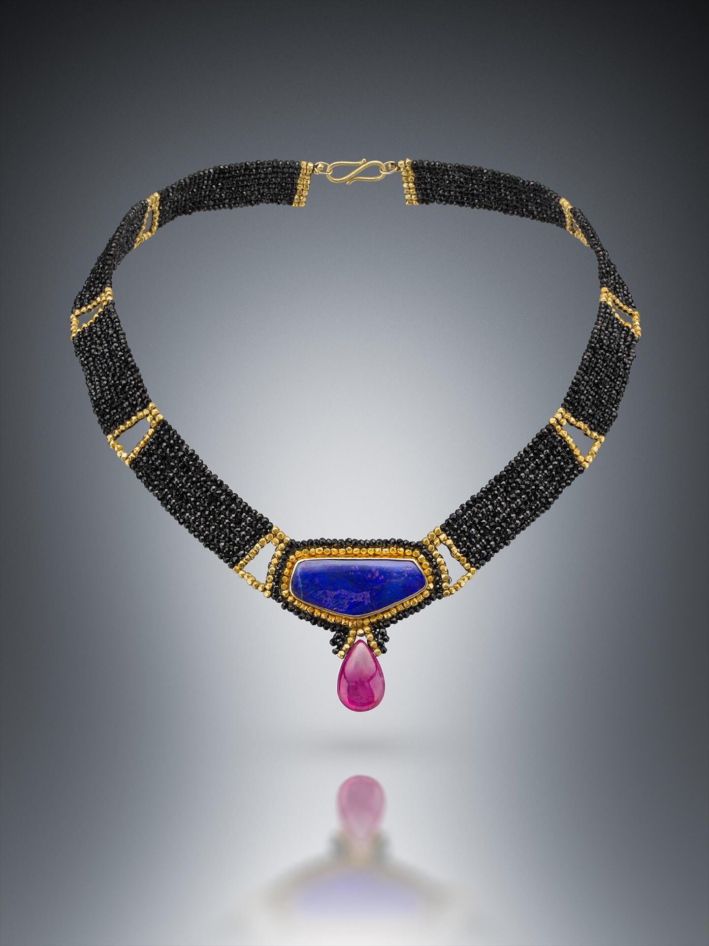 Purple Opal Choker. This choker is hand woven of black spinel and 18k gold beads. The center is a purple boulder opal from Australia in a hand fabricated setting of 18k gold. Ruby drop.
