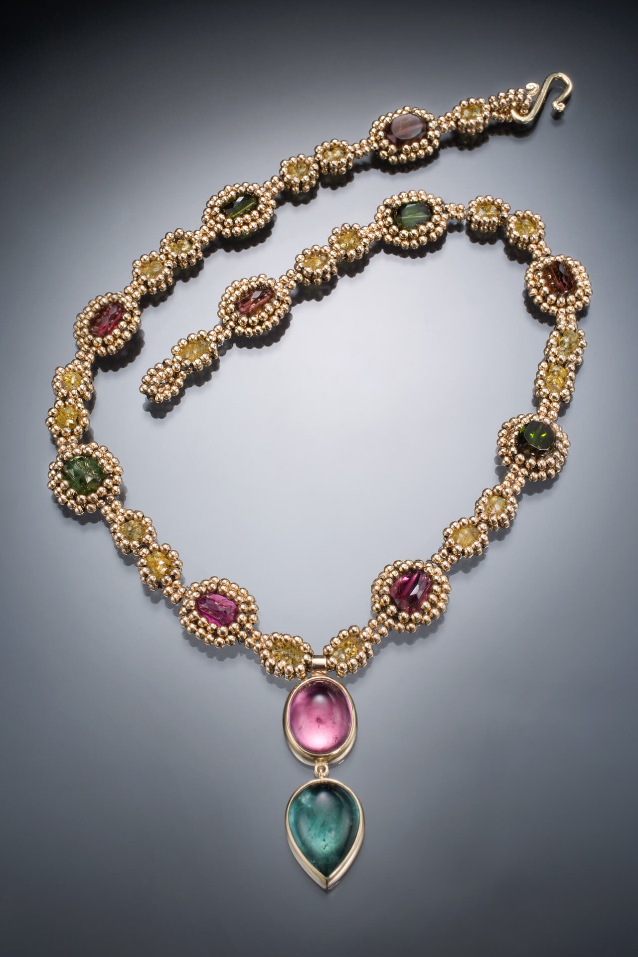 The Princess Necklace is hand woven of 14k round gold beads, yellow sapphires, and multicolor tourmaline beads. The bezels are fabricated of 14k gold and set with pink and blue tourmaline cabochons.