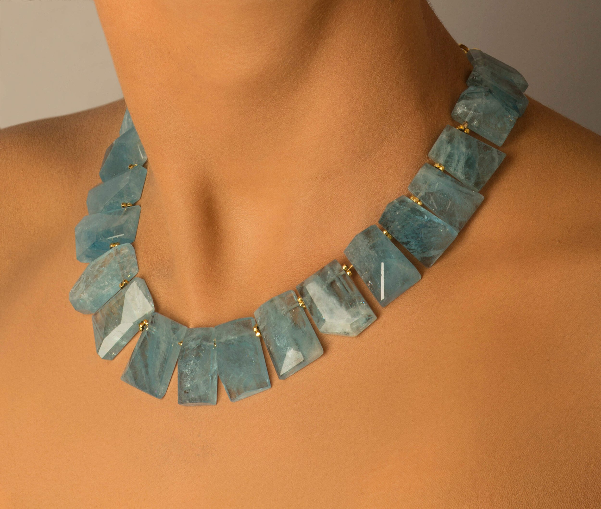 Aqua Collar. This collar is strung with large aquamarine faceted stones; tiny, round 14k beads are placed in between each of the stones.
