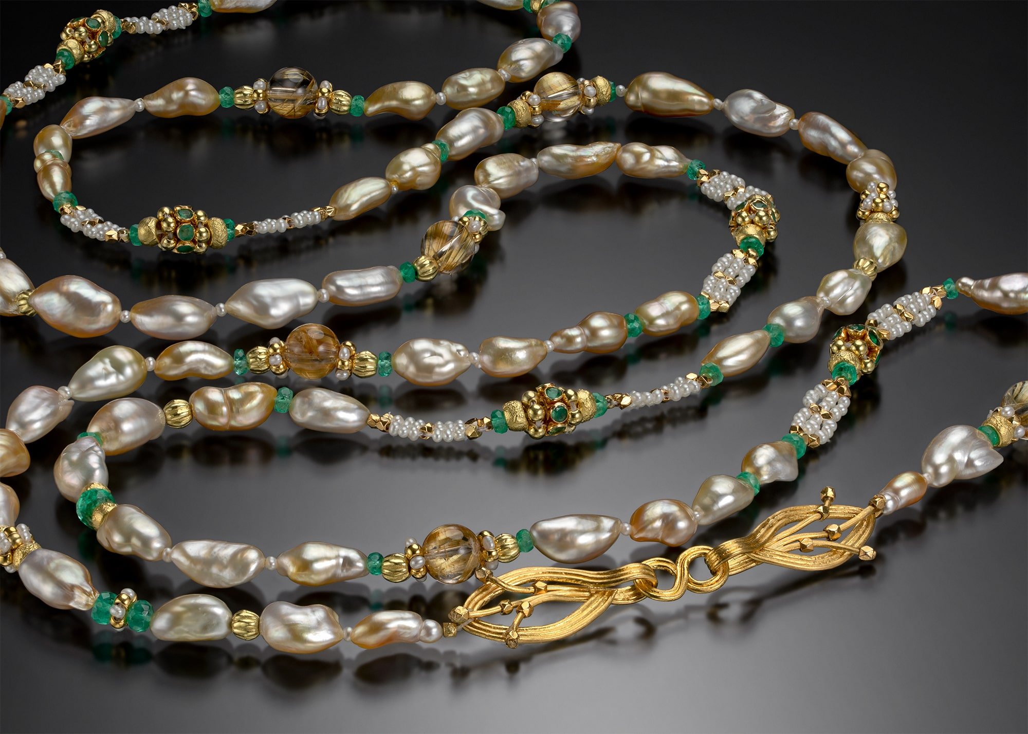 South Sea Keshi.   This long necklace is woven of South Sea keshi pearls, emeralds, tiny seed pearls, 20k and 18k gold; the clasp is hand fabricated out of 22k gold. (48 inches long)