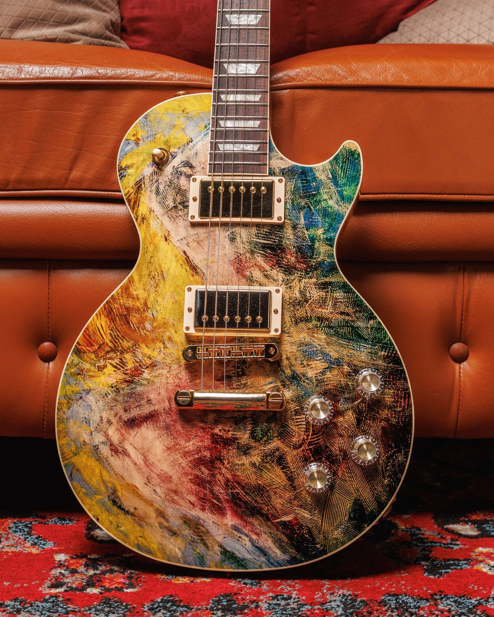 Abstract painted electric guitar on a leather couch