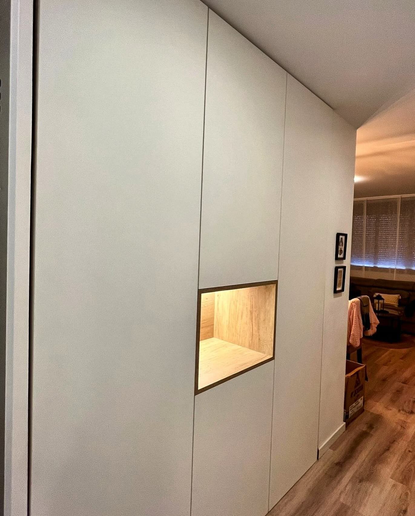 Os traemos un recibidor elegante y funcional: armario de suelo a techo con puertas blancas que aportan luminosidad y amplitud, complementado por una hornacina de madera iluminada con luz. Perfecto para dar la bienvenida con estilo.