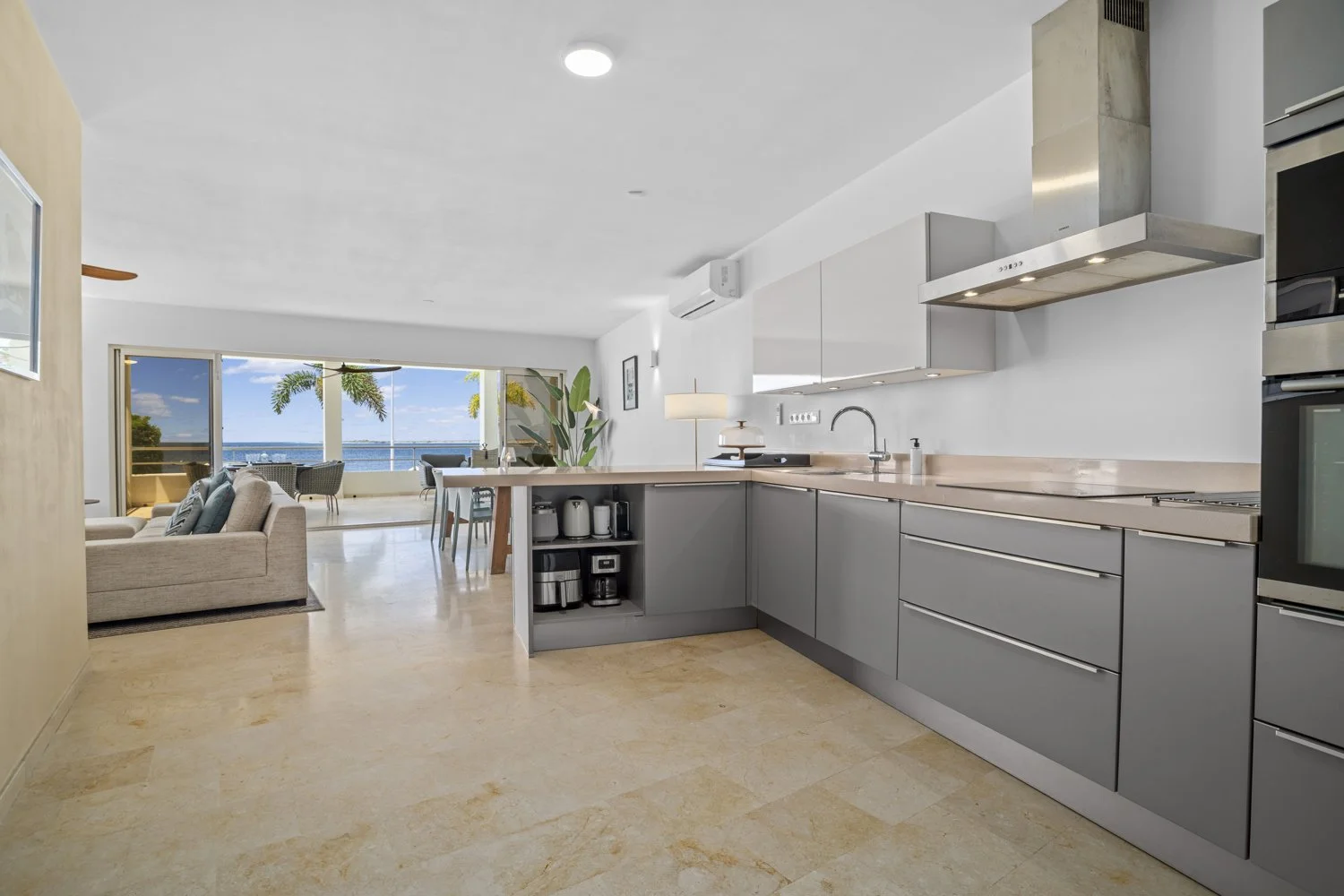 Modern appartement met open keuken, woonkamer en uitzicht op de oceaan.