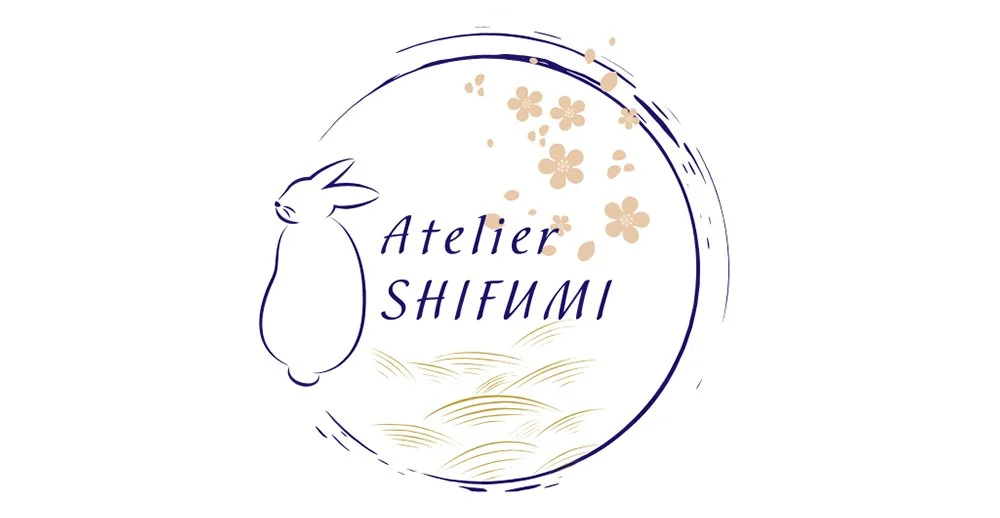 Logo de l'atelier Shifumi avec un lapin stylisé, des fleurs de cerisier et des motifs de vagues, dans un cercle.