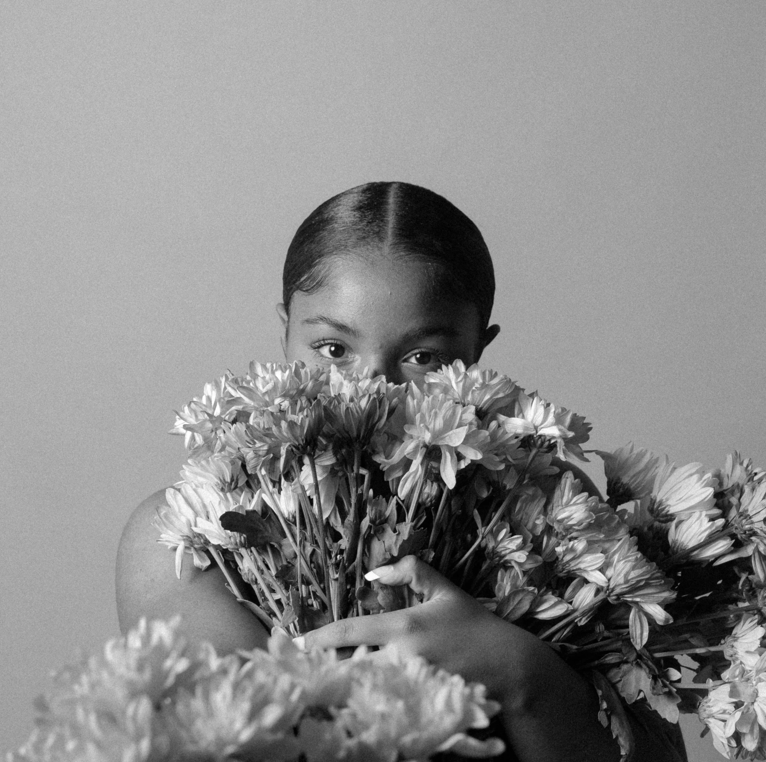 Person holding a large bouquet of flowers in black and white