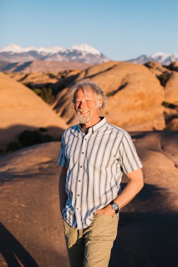 Dominic, lead bartender at Moab Bar Trailers, standing among the red rocks near Moab, Utah at sunset