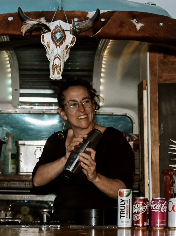 Meghan, lead bartender at Moab Bar Trailers, shaking a cocktail inside a mobile bar trailer in Moab, Utah
