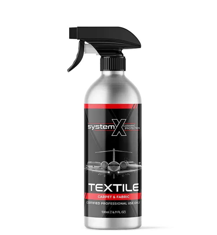 A spray bottle of System X Ceramic Protection Textile, a cleaning product for carpet and fabric, with an aircraft and cars on the black label.