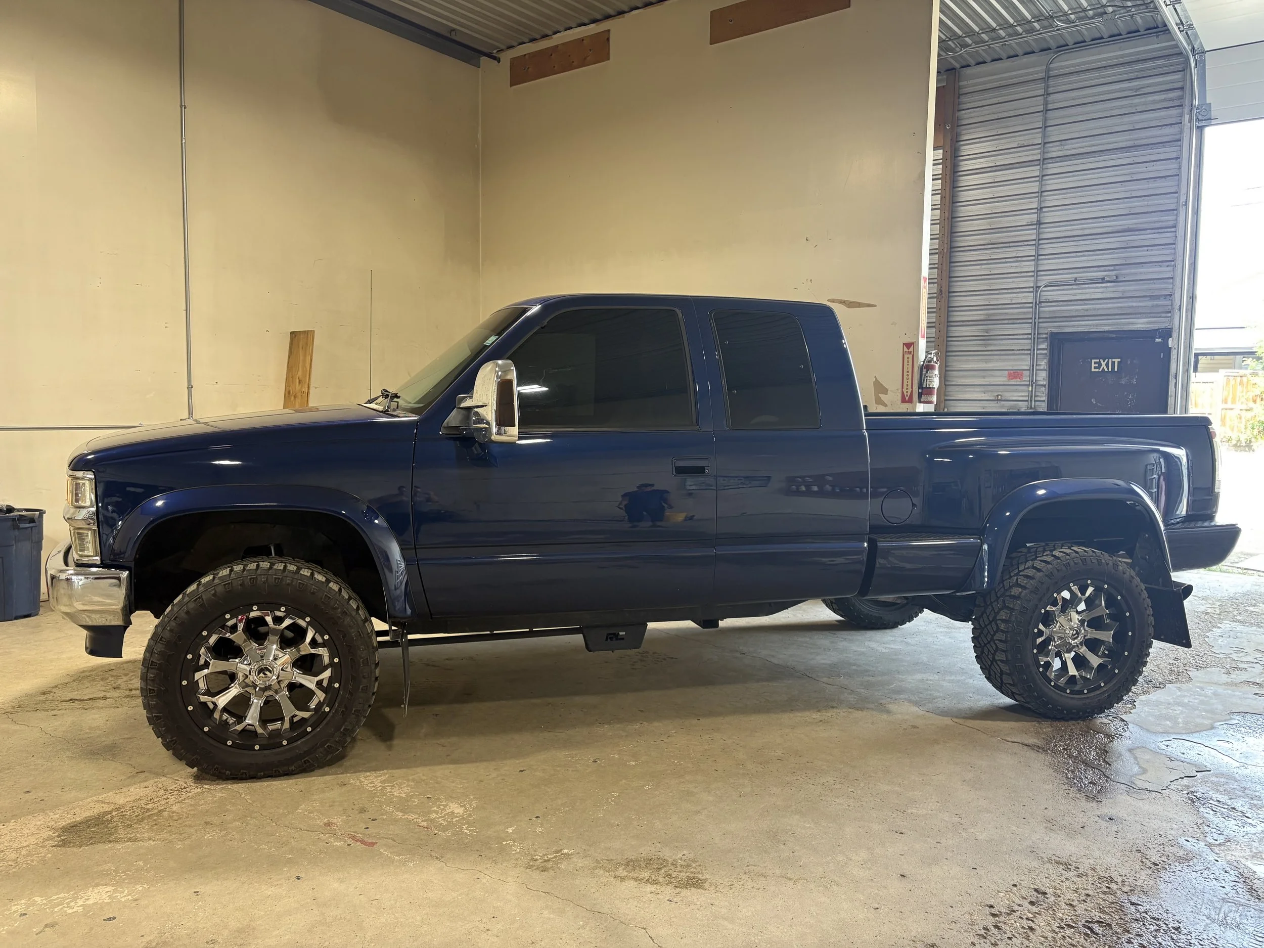 Blue pickup truck with tinted windows inside the Pick 6 shop