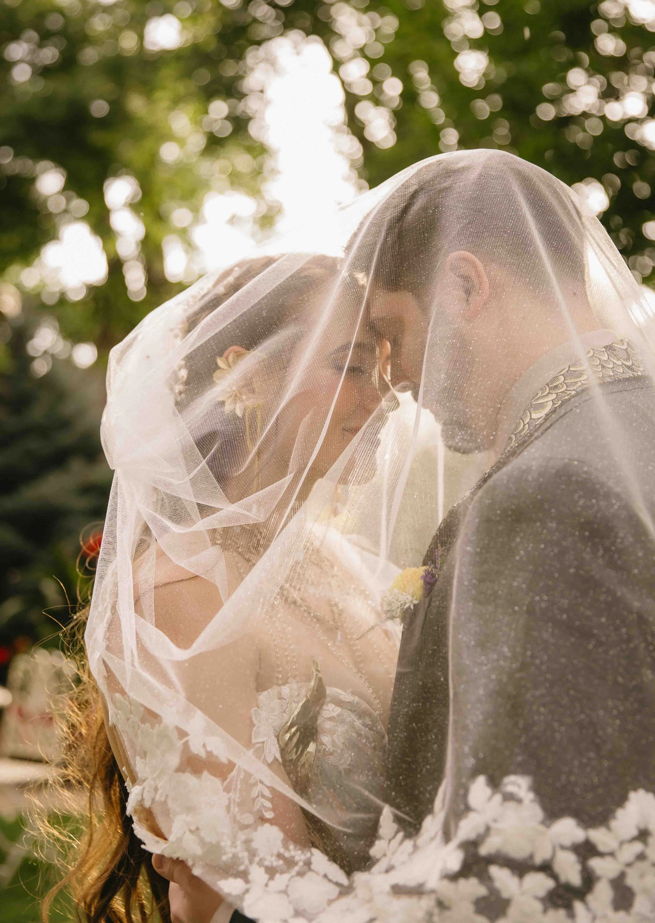 a newlywed couple embraces under the bride's veil following their fantasy dungeons and dragons themed wedding ceremony at Tapestry House in early fall autumn with beautiful fantasy nerdy details and joy surrounding them