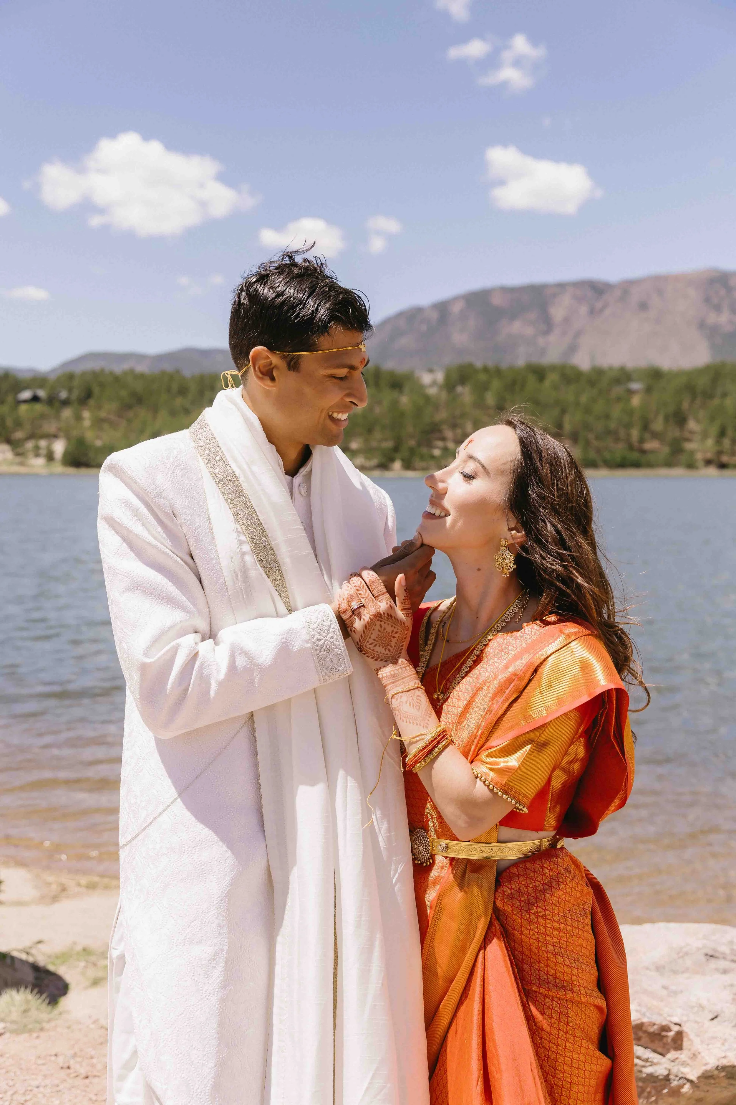 A unique wedding blending hindu and American traditions, bride and groom portraits in traditional Hindu wedding attire at the lake by their venue the hearth house