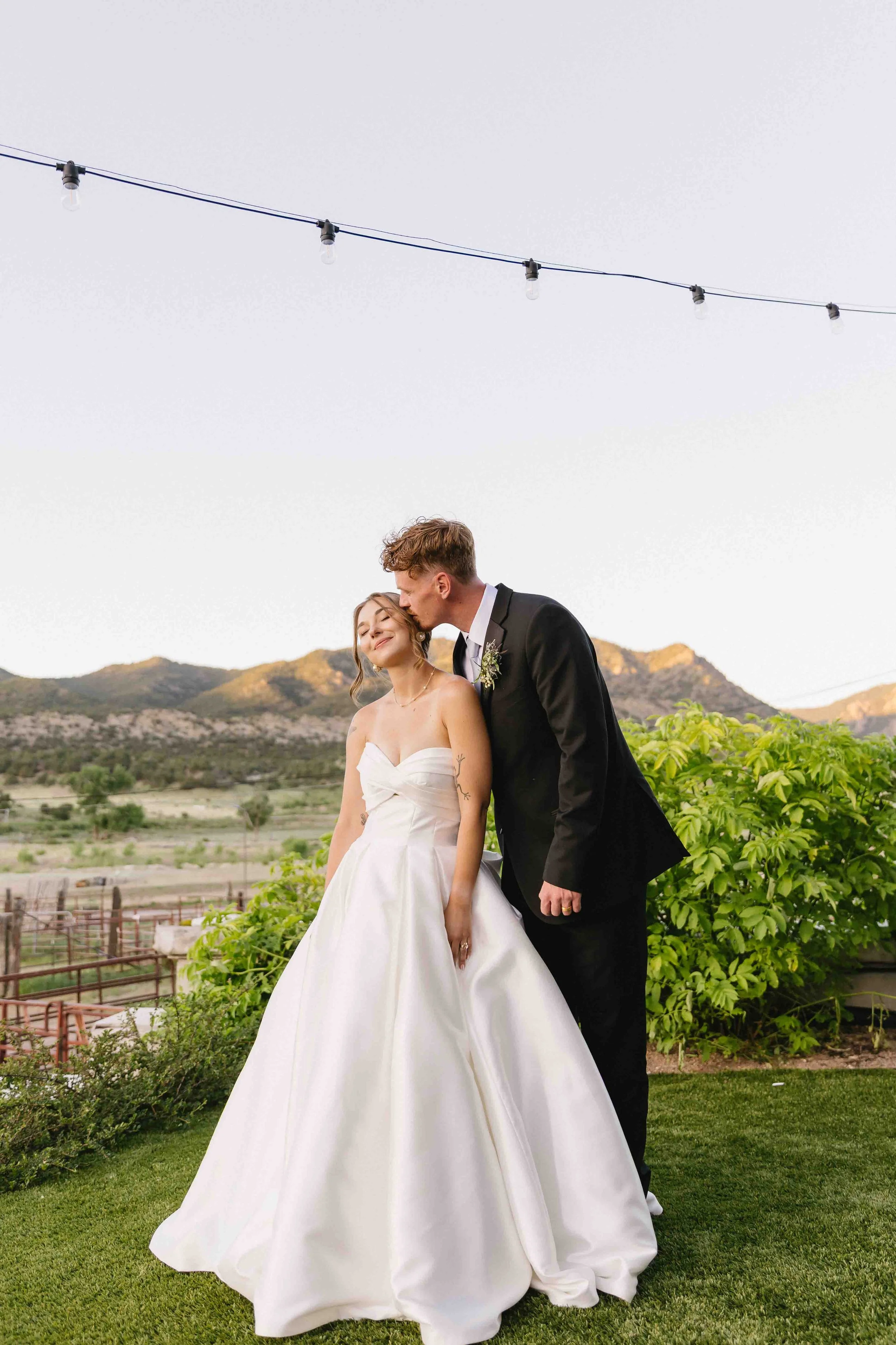 an editorial wedding couples photograph of newly weds on their wedding day at Marchand ranch in canyon city with a mountain in the background highlighted by beautiful blue hour tones