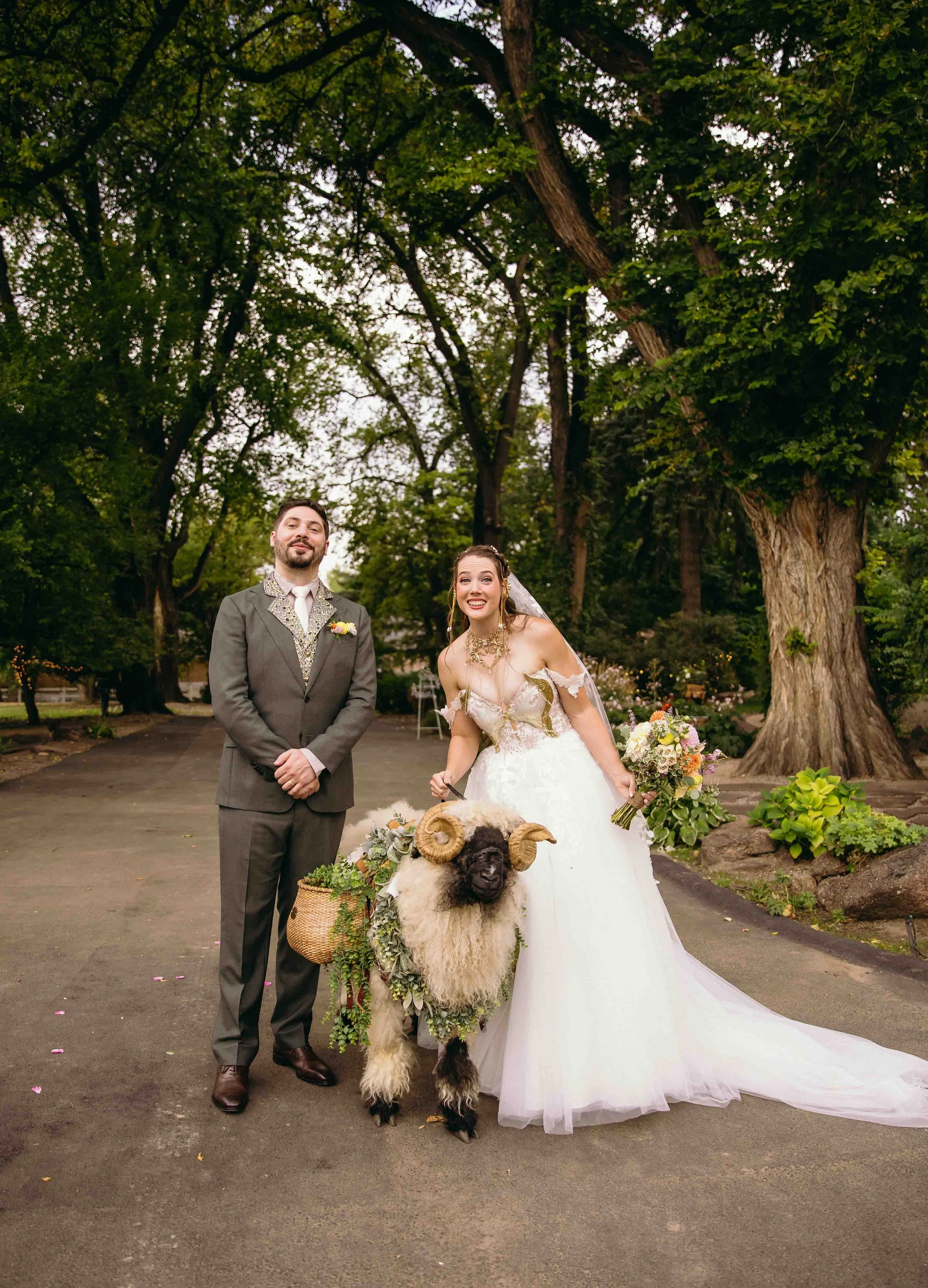 A newly wed bride and groom stand with their ring bearer sheep and pose for their first couple's photo together, at the tapestry house in Fort Collins celebrating their magical fantasy dungeons and dragons inspired wedding