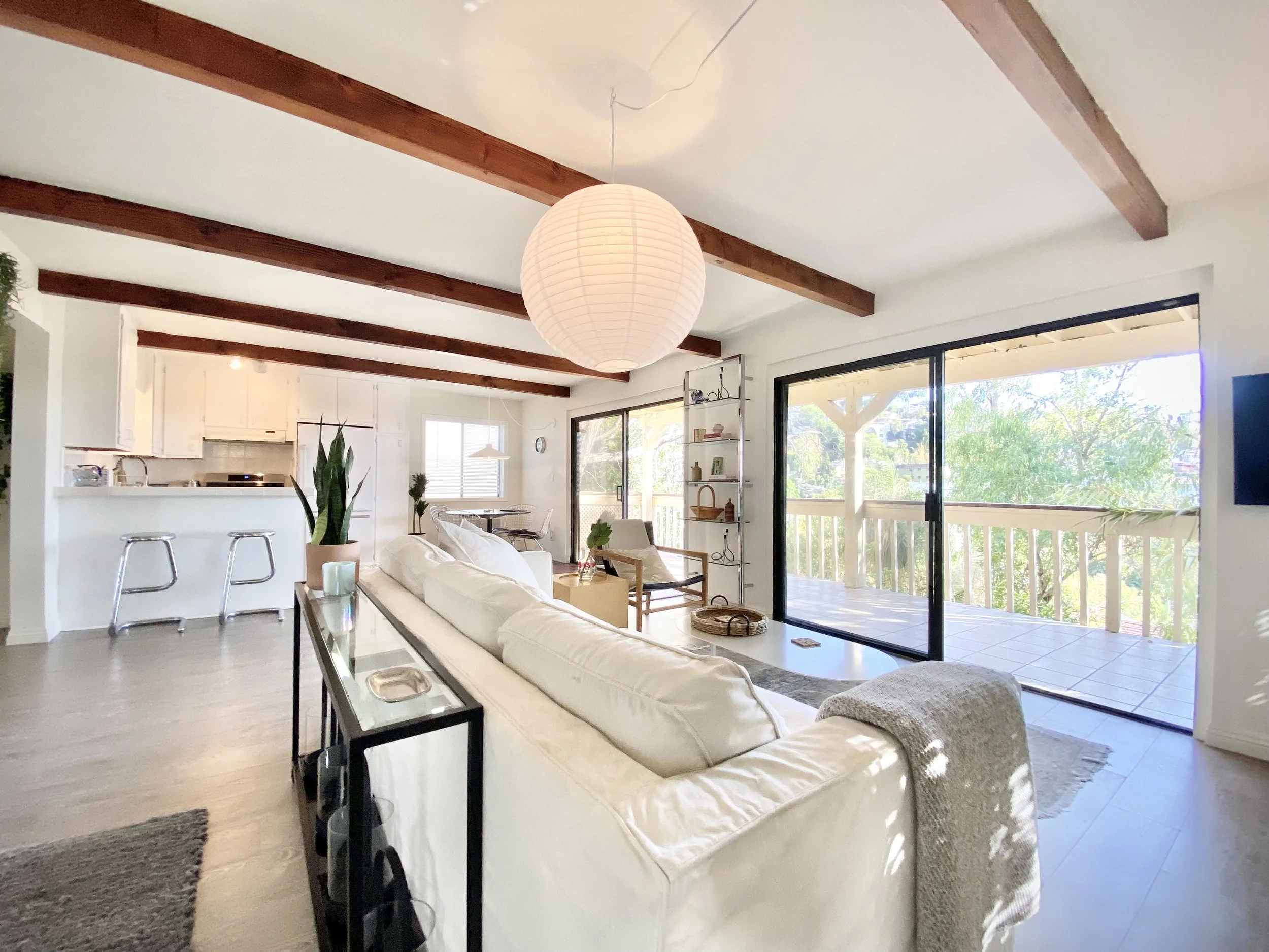 Open-plan living room and kitchen in a Franklin Hills Airbnb with exposed wood beams and hillside views