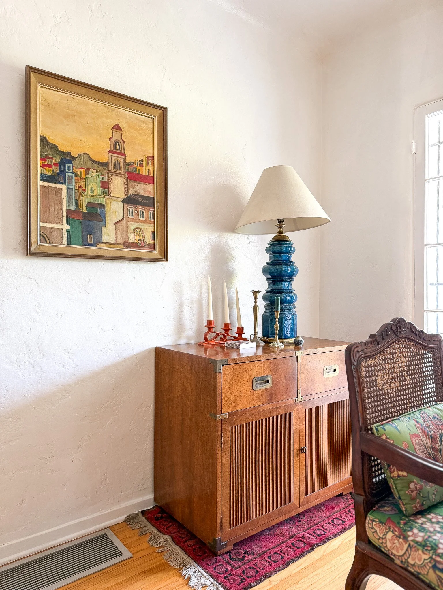 Vintage dresser, artwork and lighting details inside a Highland Park Airbnb