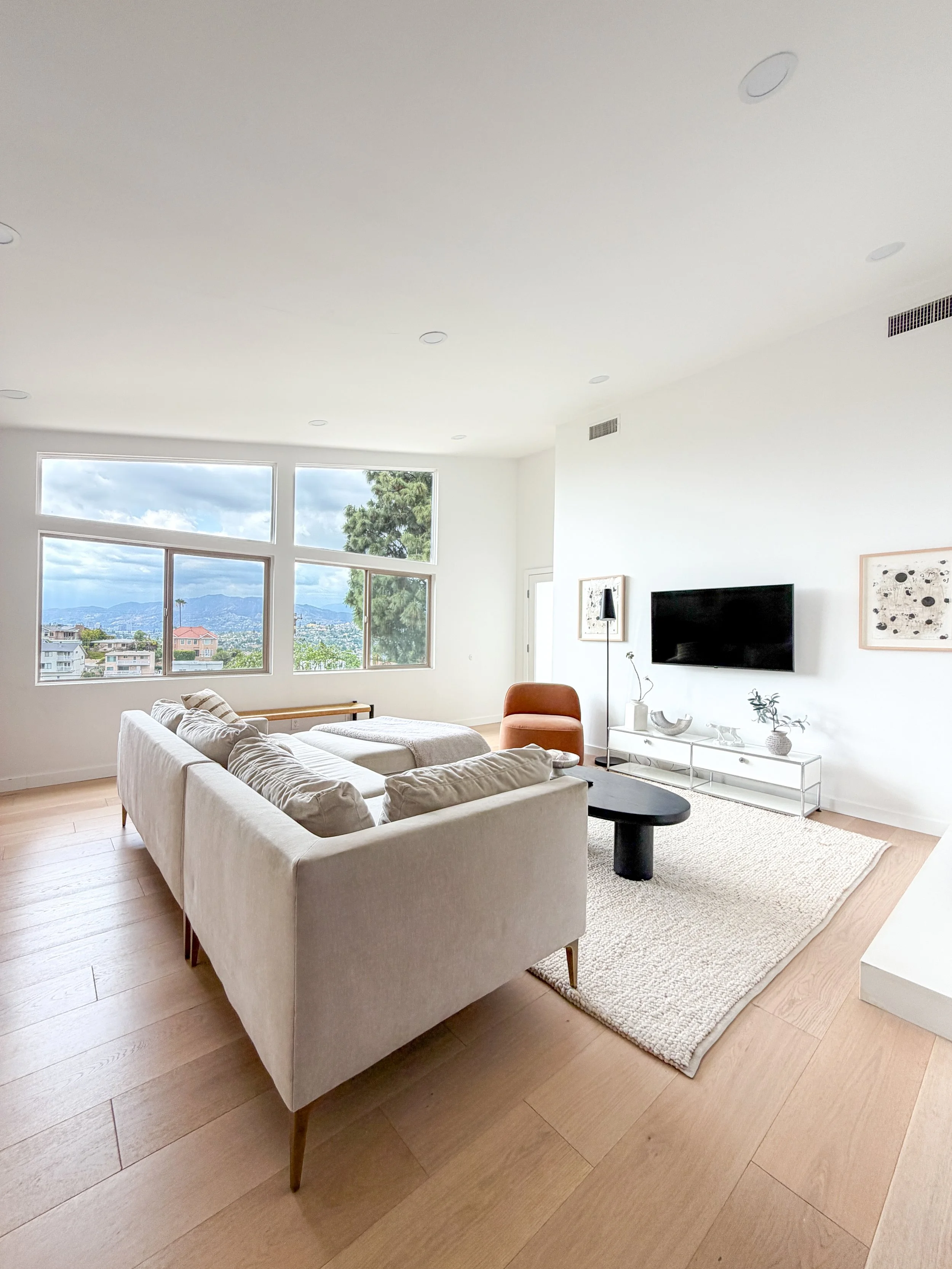 Light-filled Los Angeles Airbnb living room with large windows and hillside views
