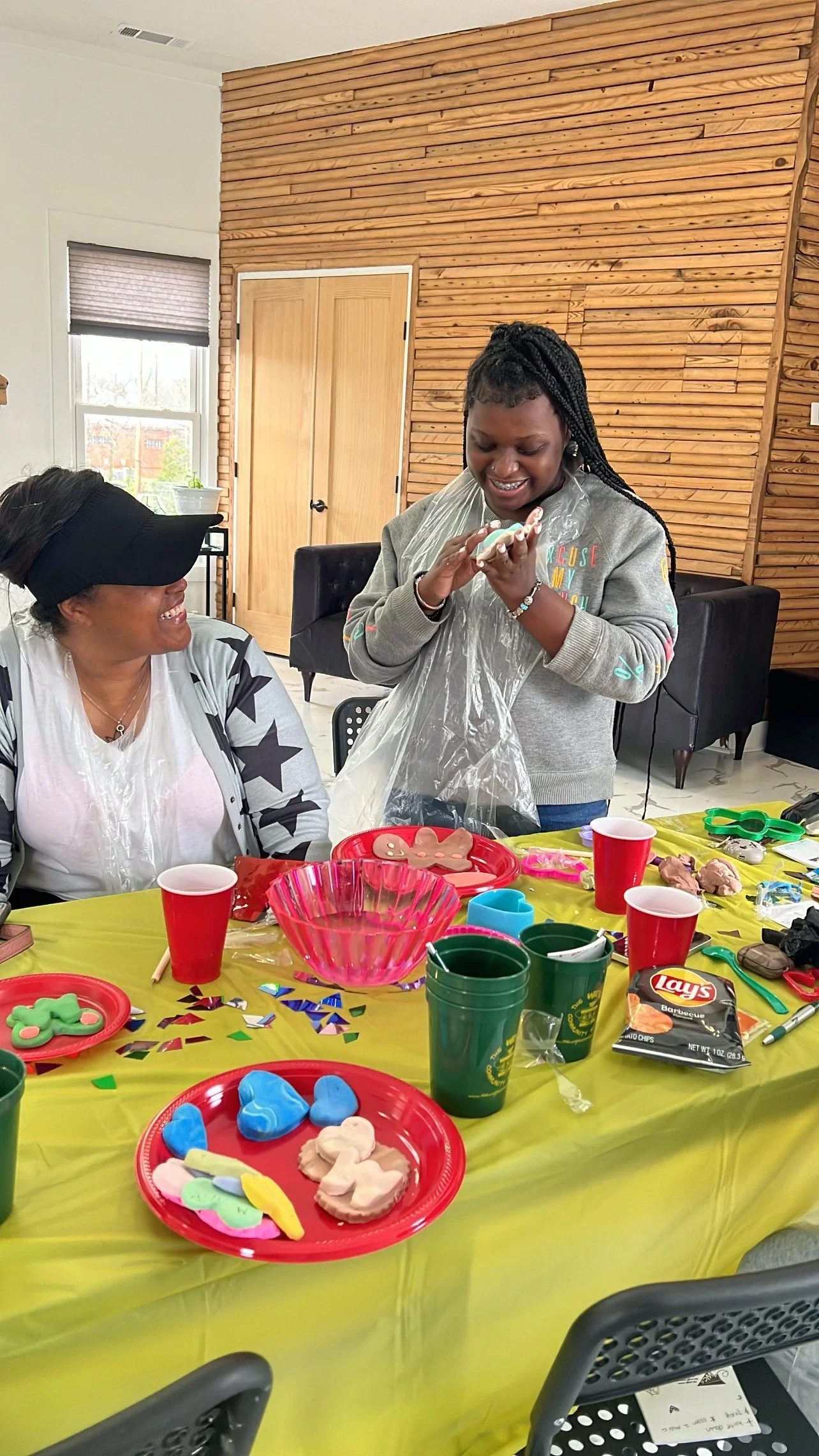 A student and an adult making clay art together