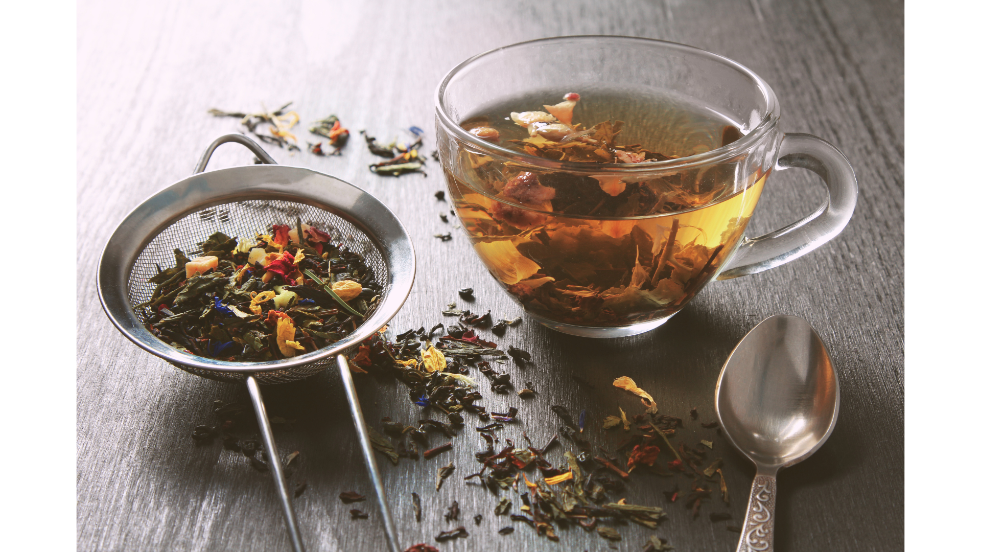 Loose leaf herbal tea in a mesh strainer and steeping in a cup of hot water to make tea.