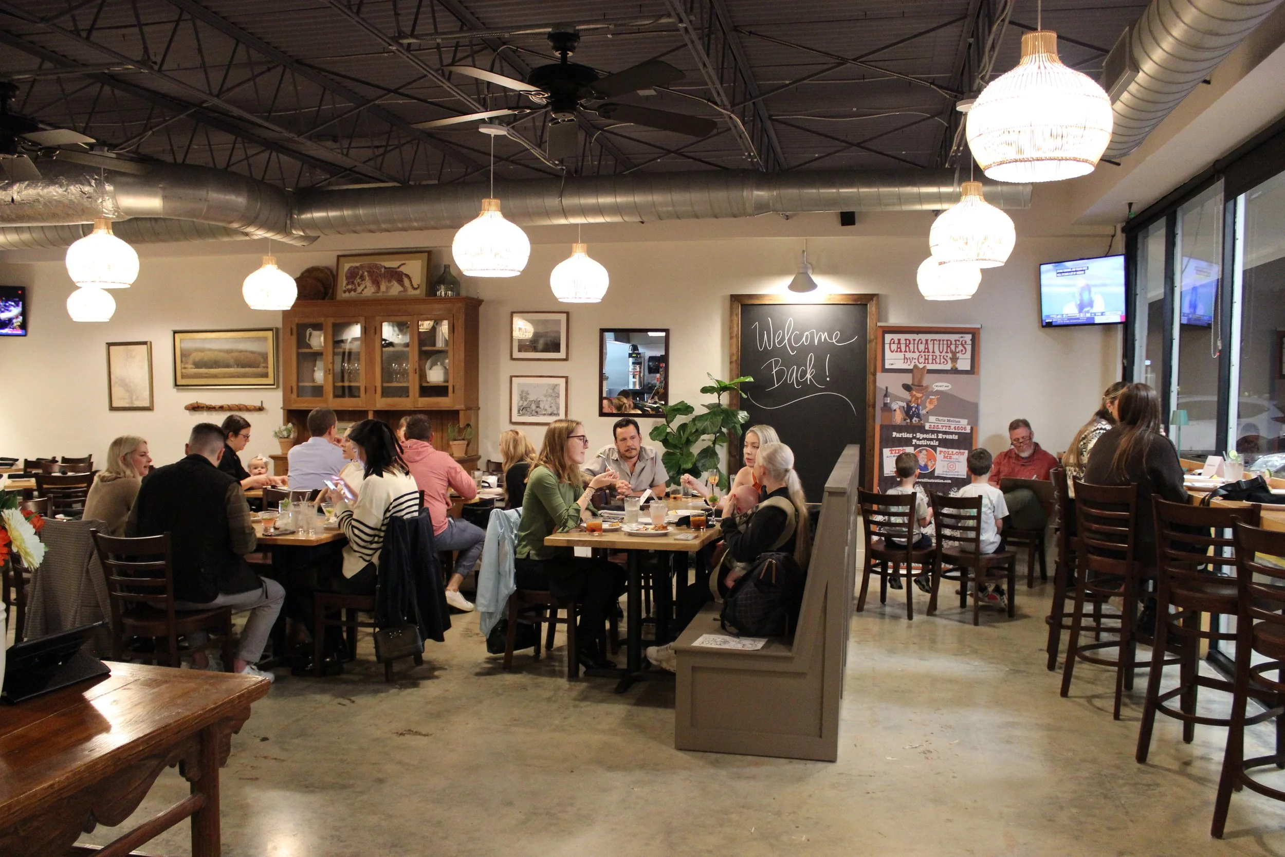 Friends and families sharing dinner in the dining room at JED’s Local in Mid City Baton Rouge