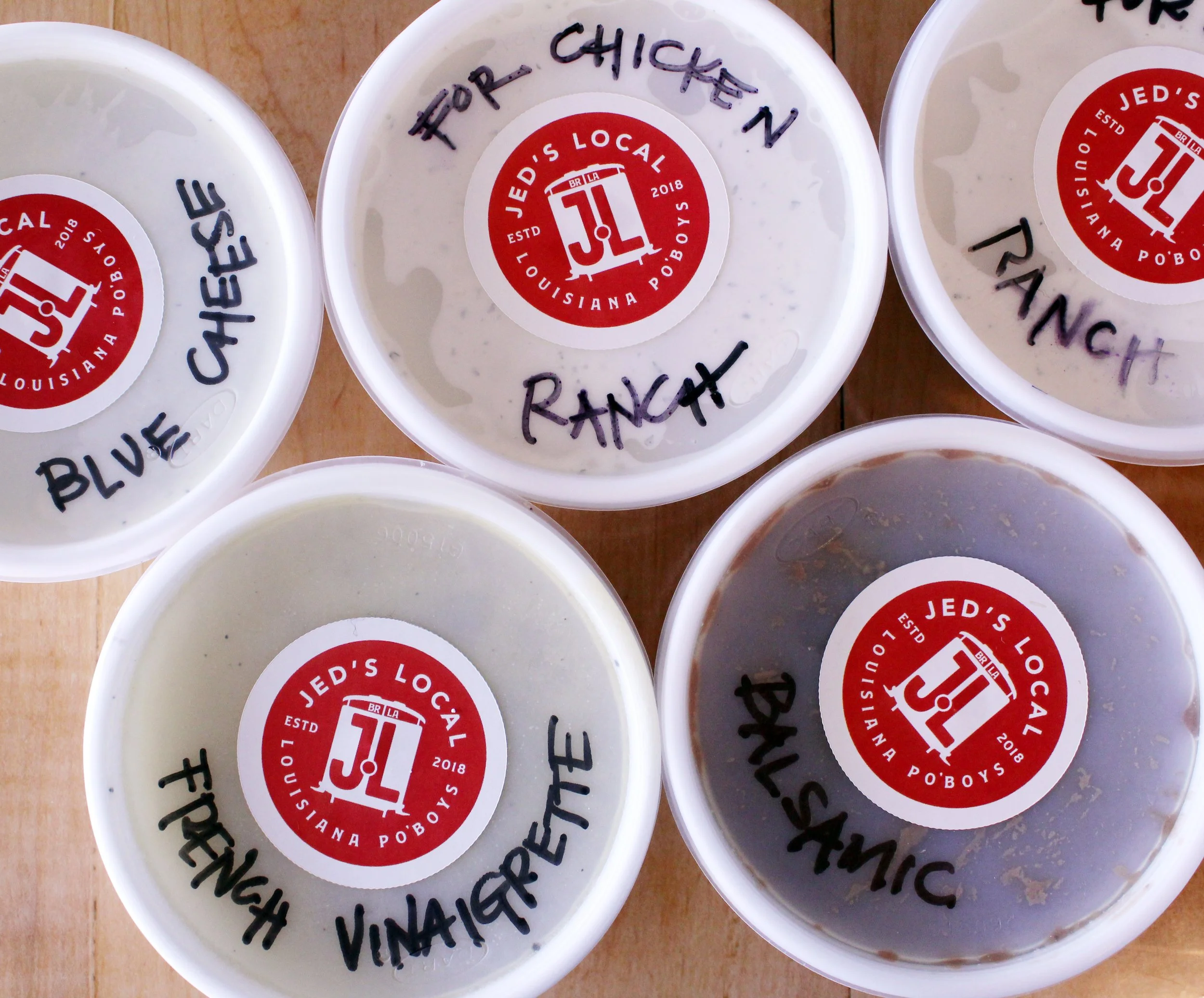 Assorted house-made sauces and dressings prepared for tailgate spread at Jed’s Local