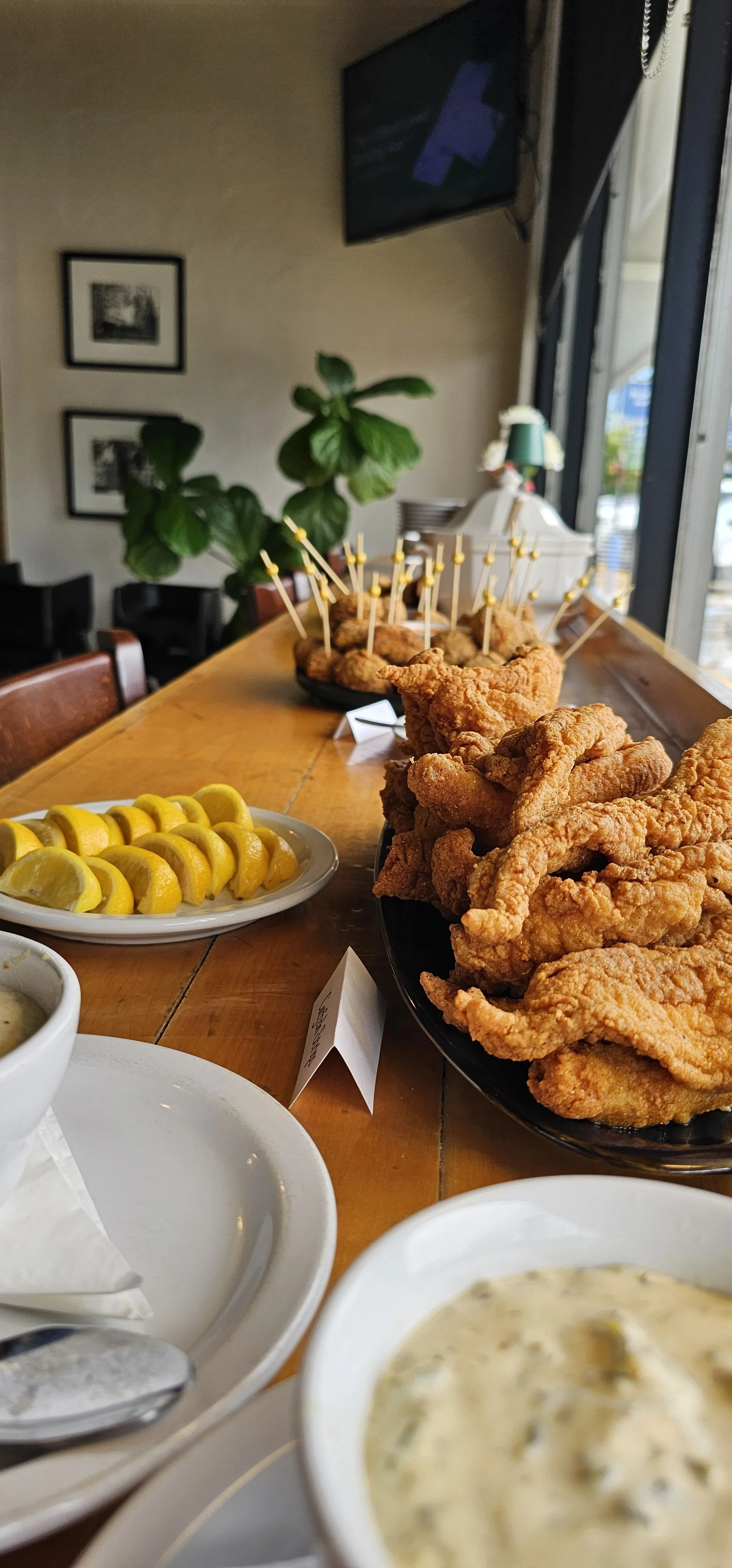 Louisiana buffet of fried Gulf catfish, boudin balls, lemon wedges and tartar sauce for a private party at JED’s
