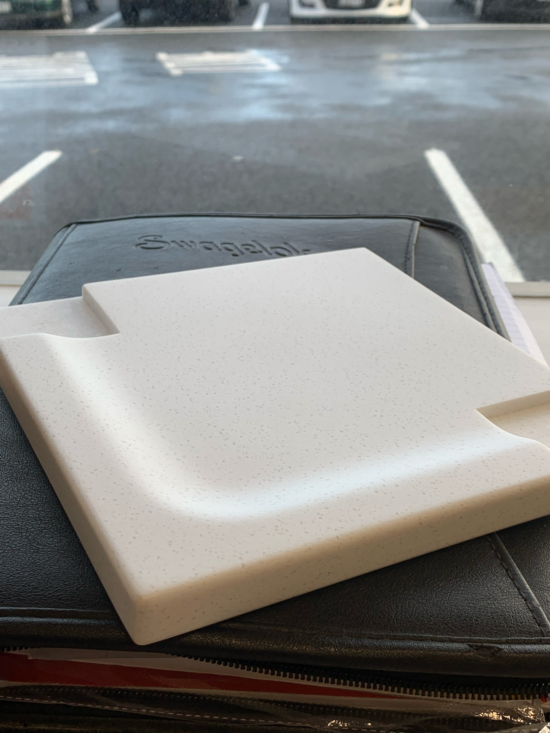 A sample of a built up edge solid surface benchtop, with the box slightly open showing the device inside.