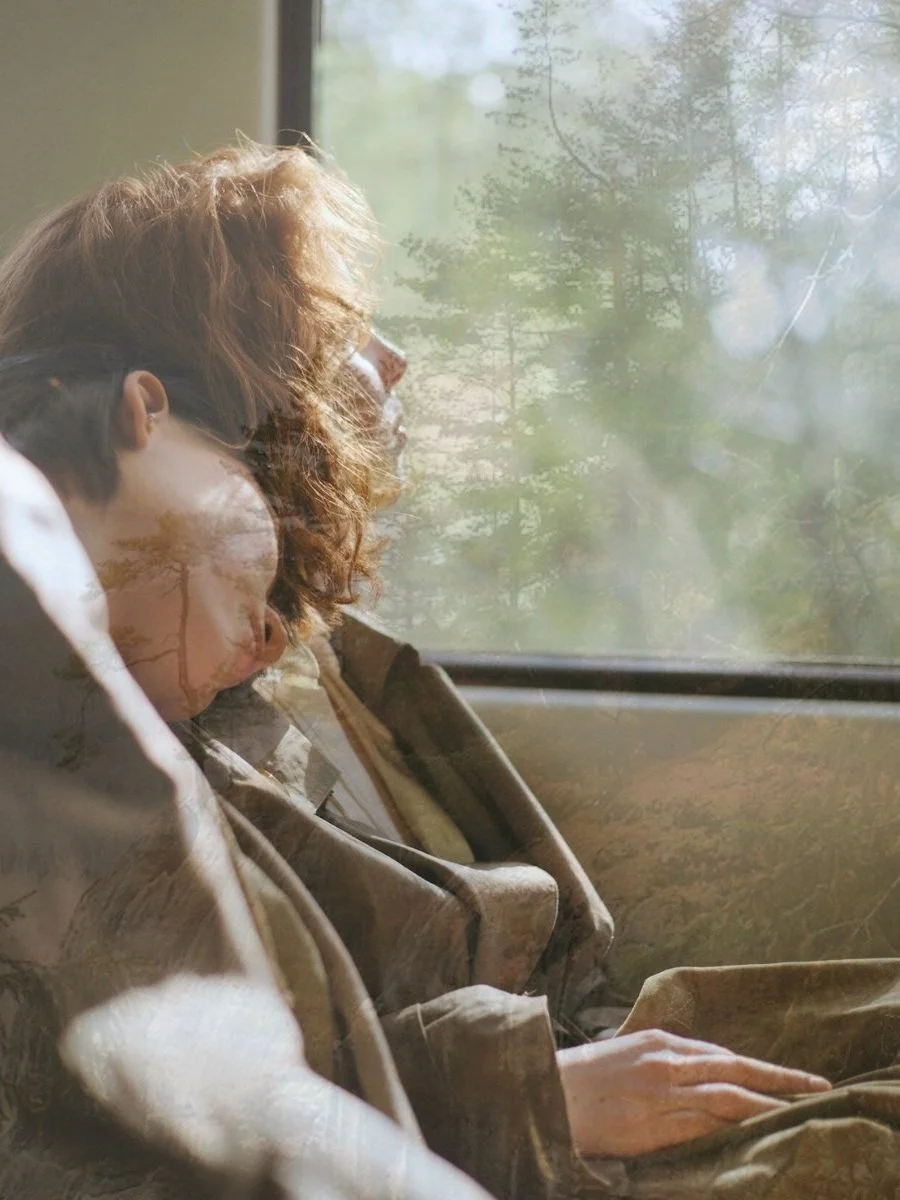 Two women sitting on a train with one friend looking out the window