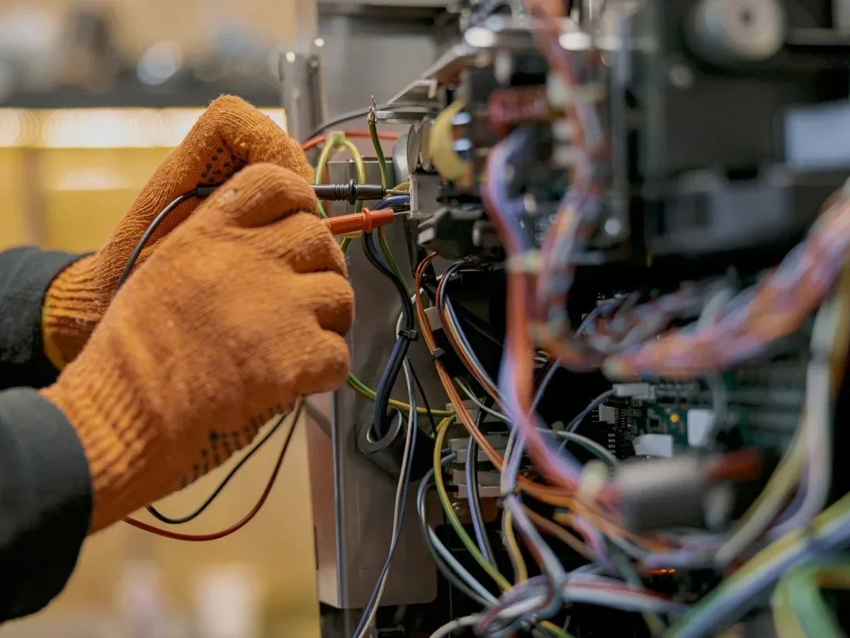 Gloved hands working on electrical circuit board