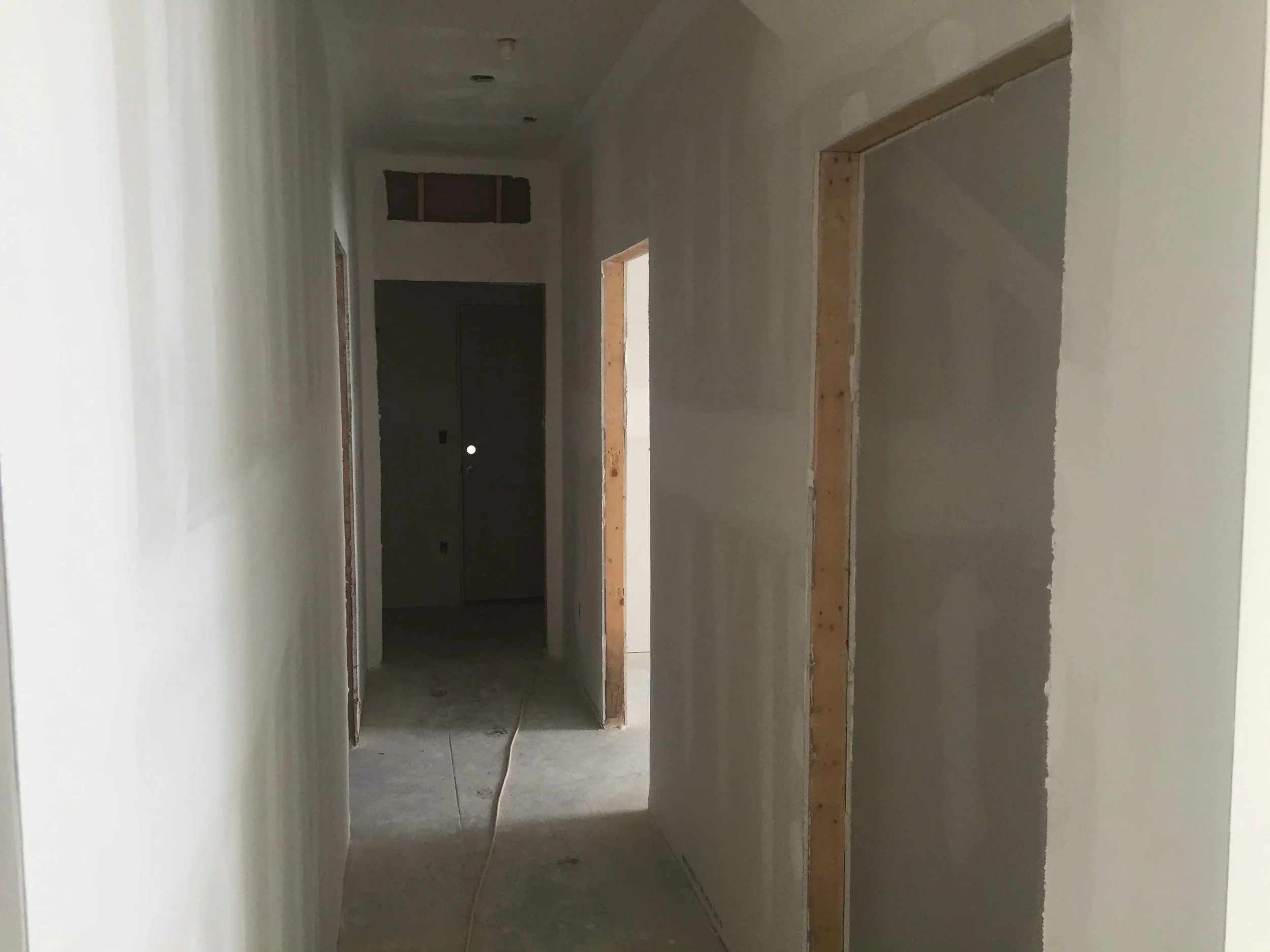 Hallway walls with newly hanged drywall prepped for painting