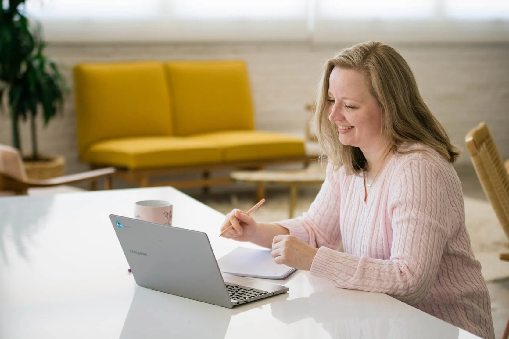 woman looking at laptop on desk and smiling