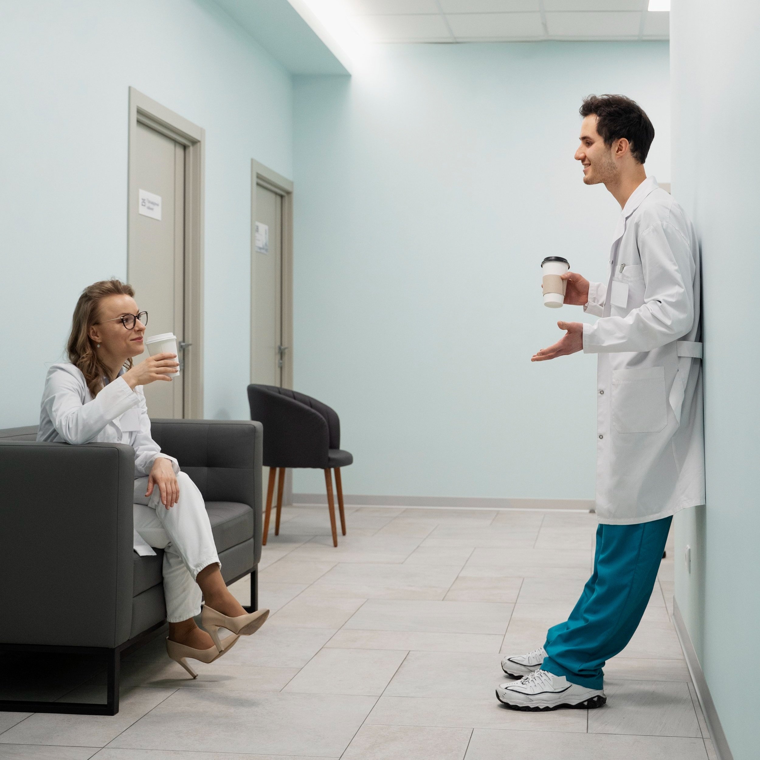 full-shot-doctors-chatting-hallway.jpg