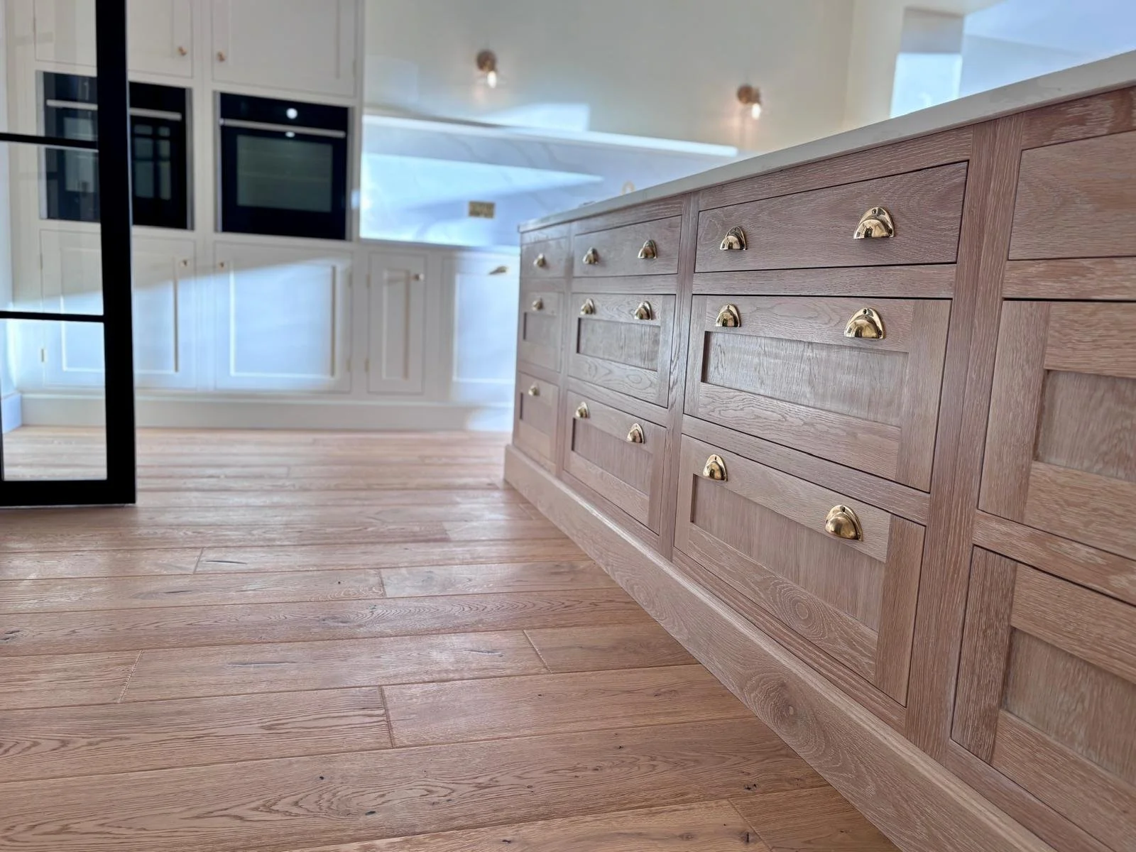 Handmade shaker style kitchen with oak island, quartz worktops and oak flooring in a West Bridgford kitchen extension built by Butterworth & Martin