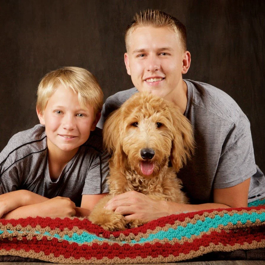 Portrait of two brothers with goldendoodle