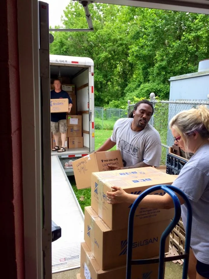 A group of people are unloading boxes from a truck into a building.