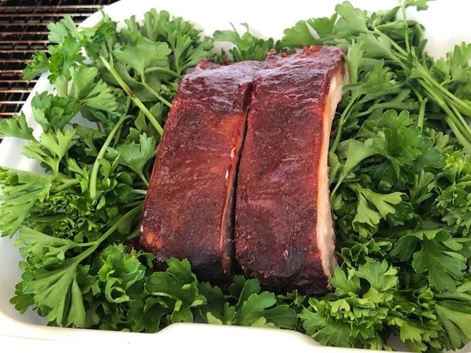 barbecued ribs on a foam plate of lettuce