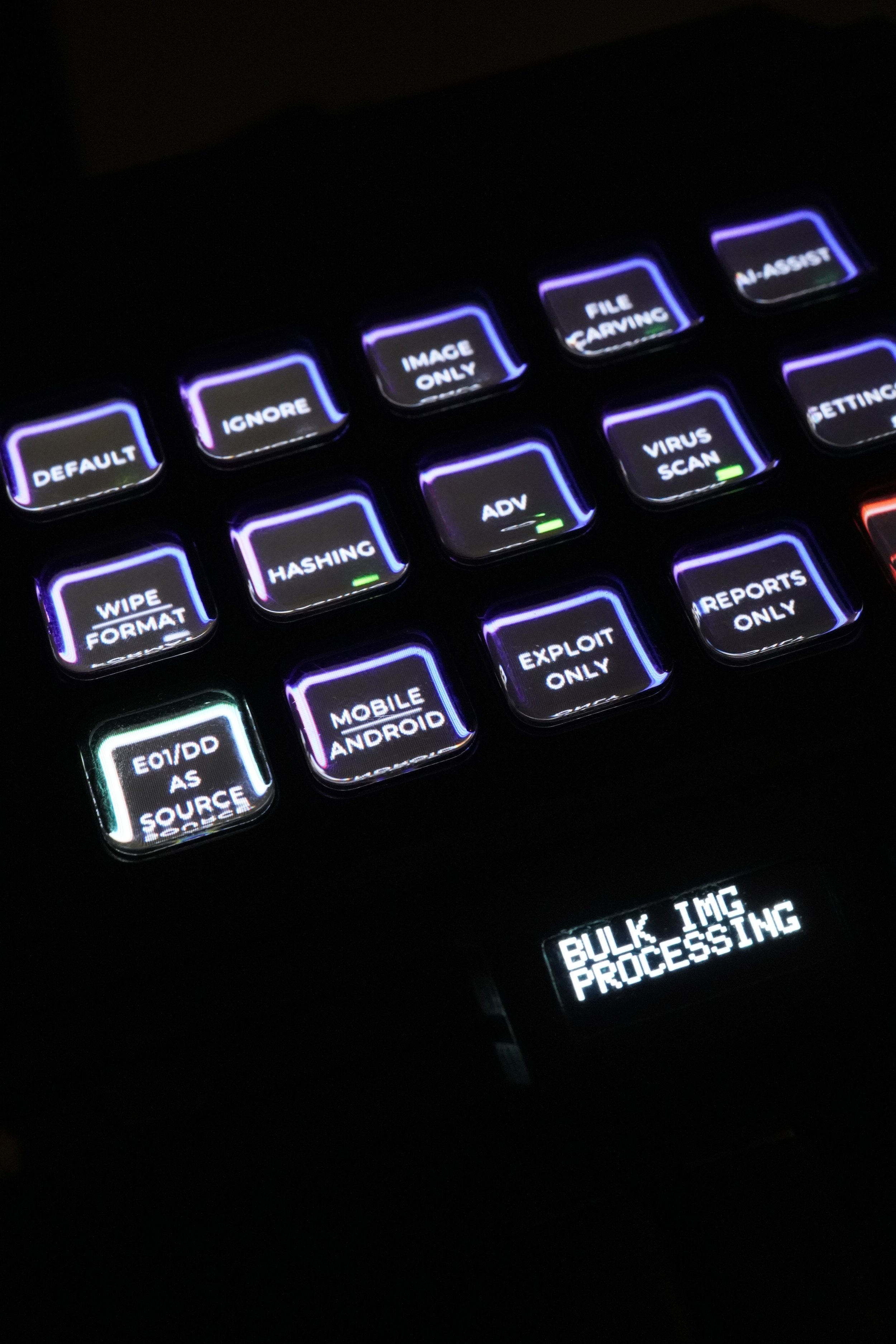 Close-up of ATRIO keypad with illuminated keys labeled for various functions related to image processing and cybersecurity, with a small display screen showing 'BULK IMG PROCESSING'.