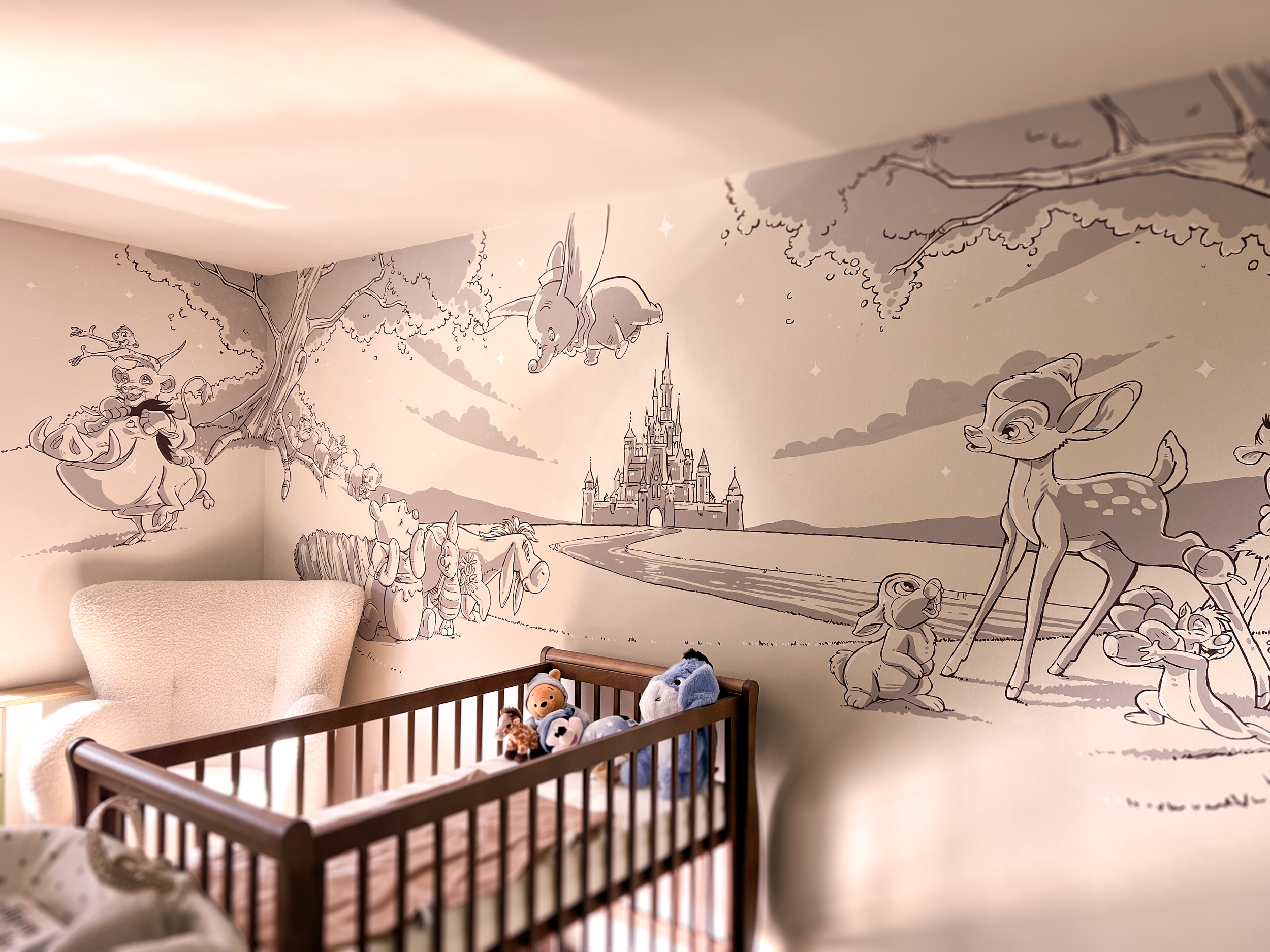 Een babykamer met een muurschildering van een sprookjesbos, inclusief een kasteel in de achtergrond, met speelornamenten in een wiegje onderaan.