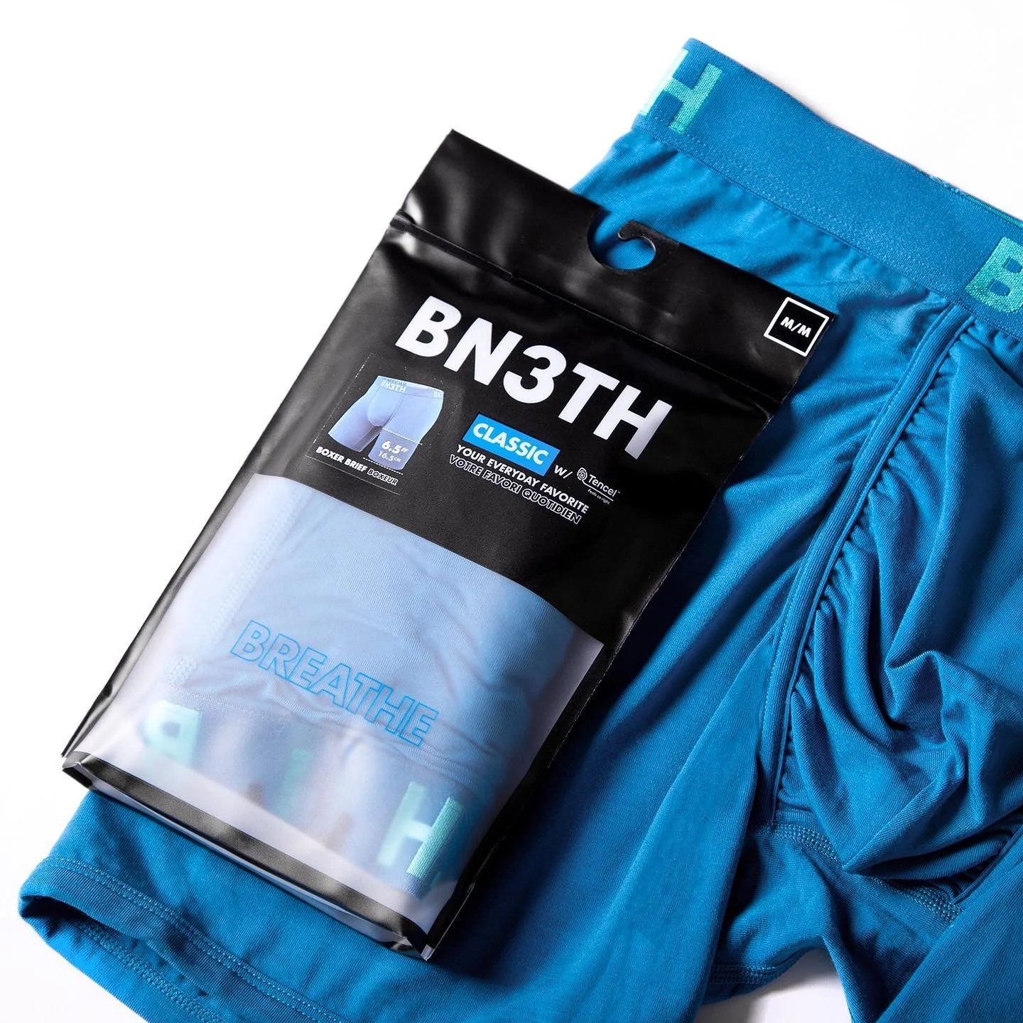 A package of men's boxer briefs placed on a pair of blue boxer briefs.
