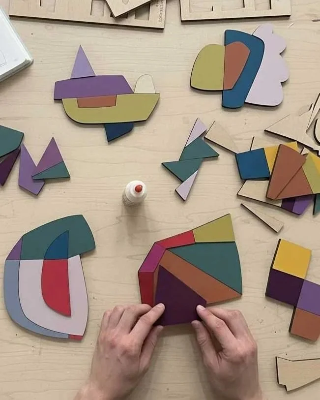 Someone assembling colorful puzzle pieces on a light-colored table.