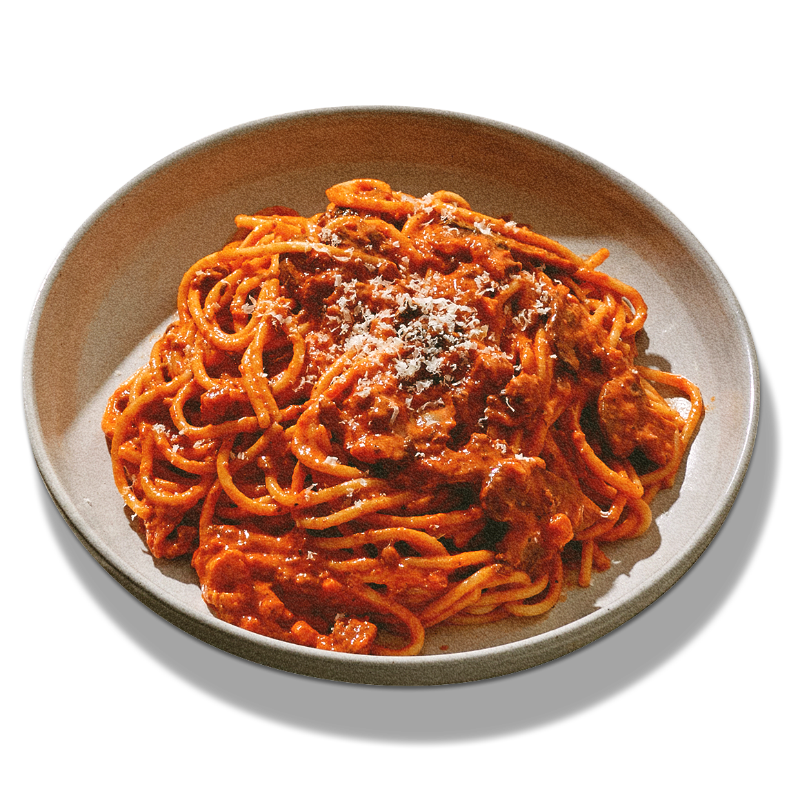 Plate of spaghetti with meat sauce topped with grated cheese.