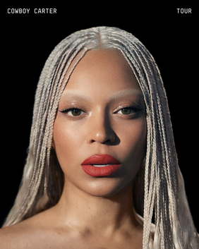 Close-up of a woman with blond braided hair and bold red lipstick, looking directly at the camera with a black background