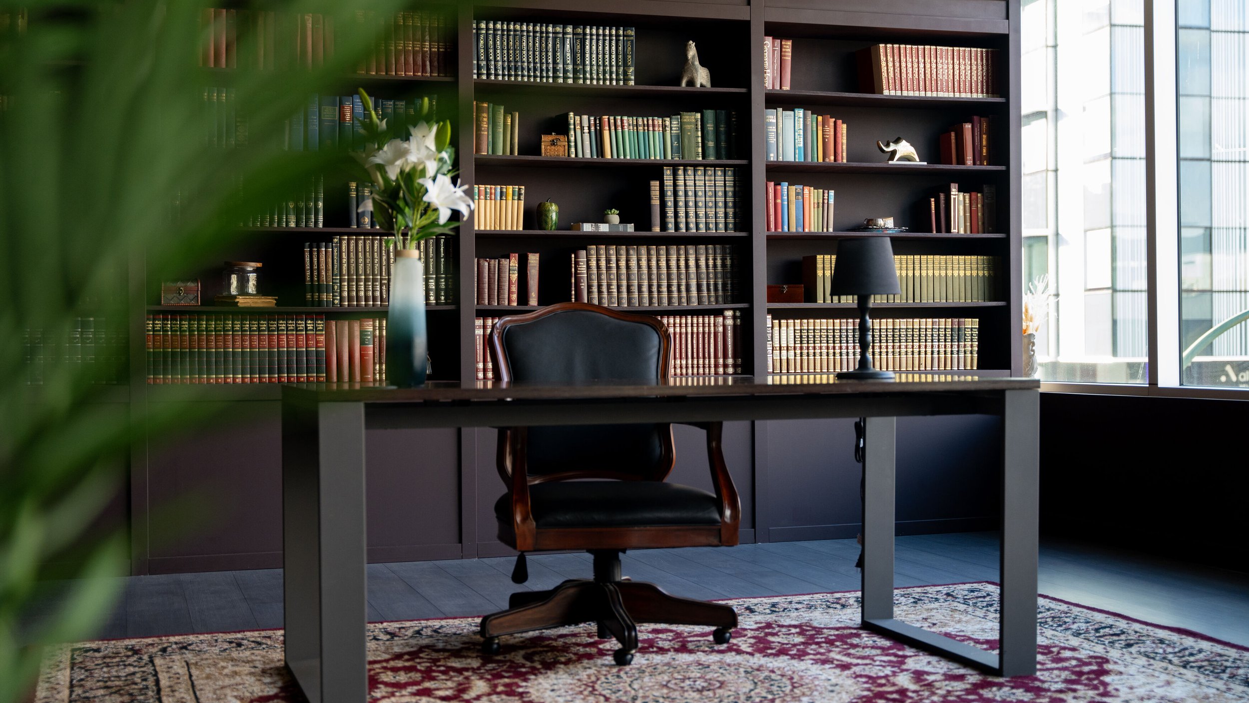 Vintage bookshelves, a modern office desk, and a warm vintage atmosphere create a unique and sophisticated environment.