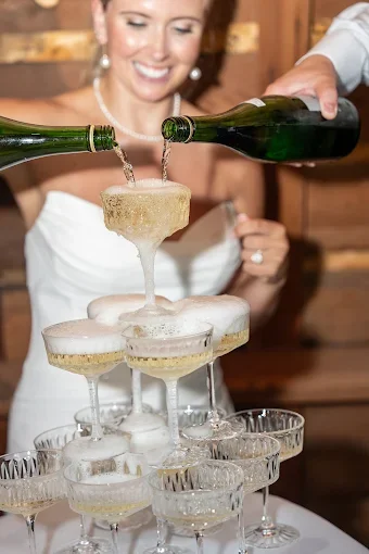 A high end service of a champagne tower pour for a wedding bar.