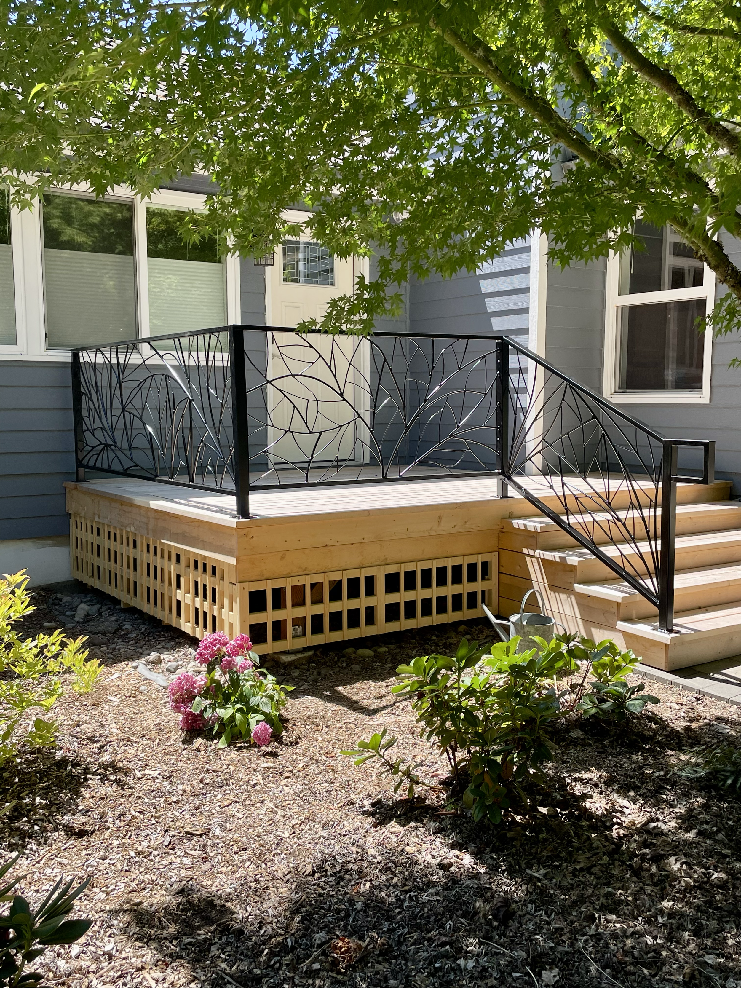 A lovely front porch with a brand new handrail and a custom fabrication fence with woven metal nature patterns.