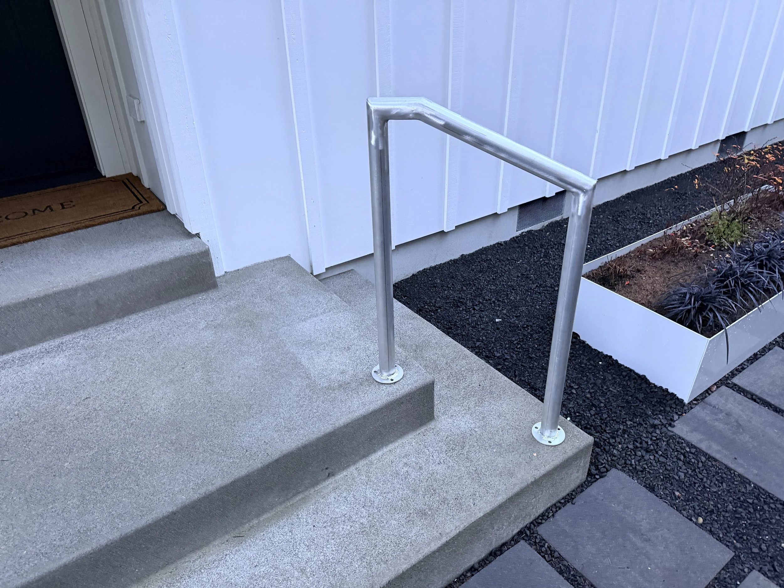 A hand-build handrail for accessibility improvement on a front step.