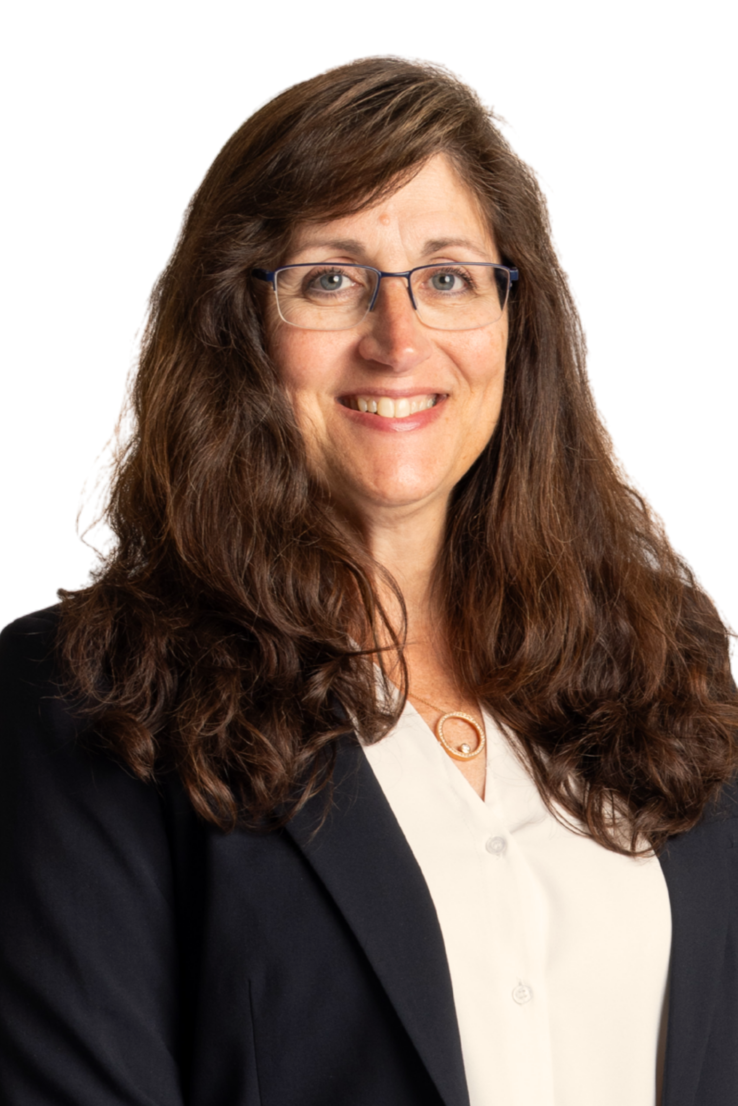 A woman with long brown hair and glasses smiling at the camera, dressed in professional attire with a white shirt and black blazer, against a white background.