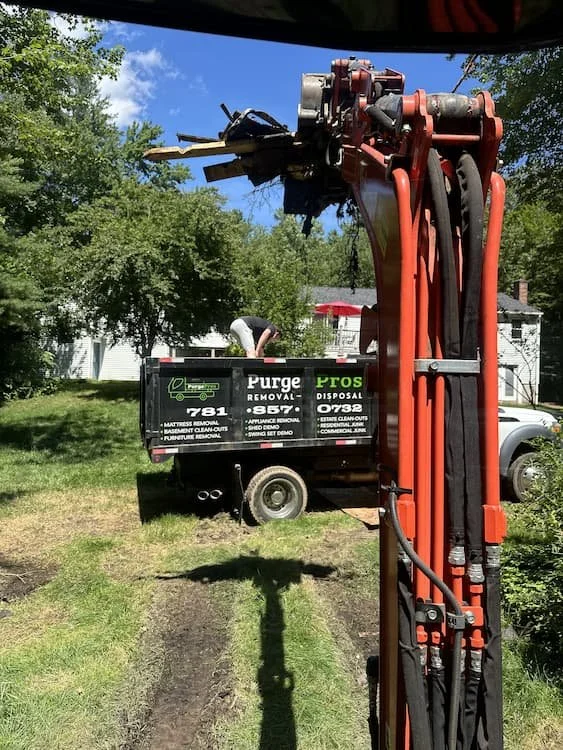 PurgePros truck being loaded with debris from a demolition project to be removed and disposed of.