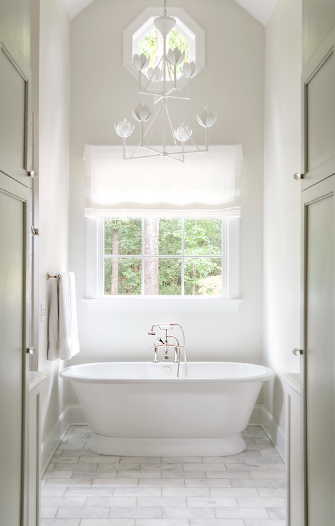 Modern transitional primary bathroom with freestanding soaking tub and large window